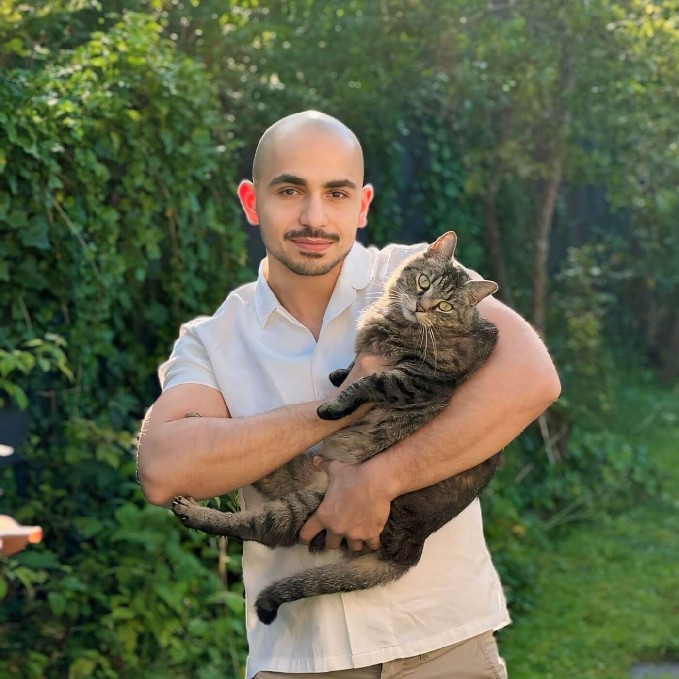 Pepe eine Britisch Kurzhaar und sein Katzenbesitzer Dilhan posieren